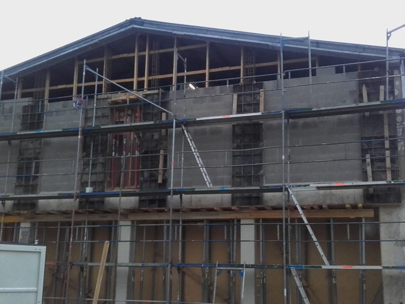 Neu aufgebaute zweigeschossige Giebelwand eines Gebäudes, eingerüstet