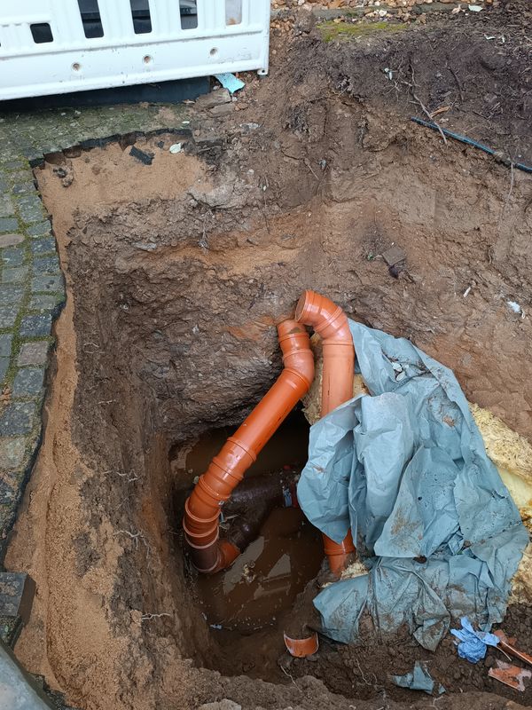Offene Baugrube mit neuen Kanalrohren
